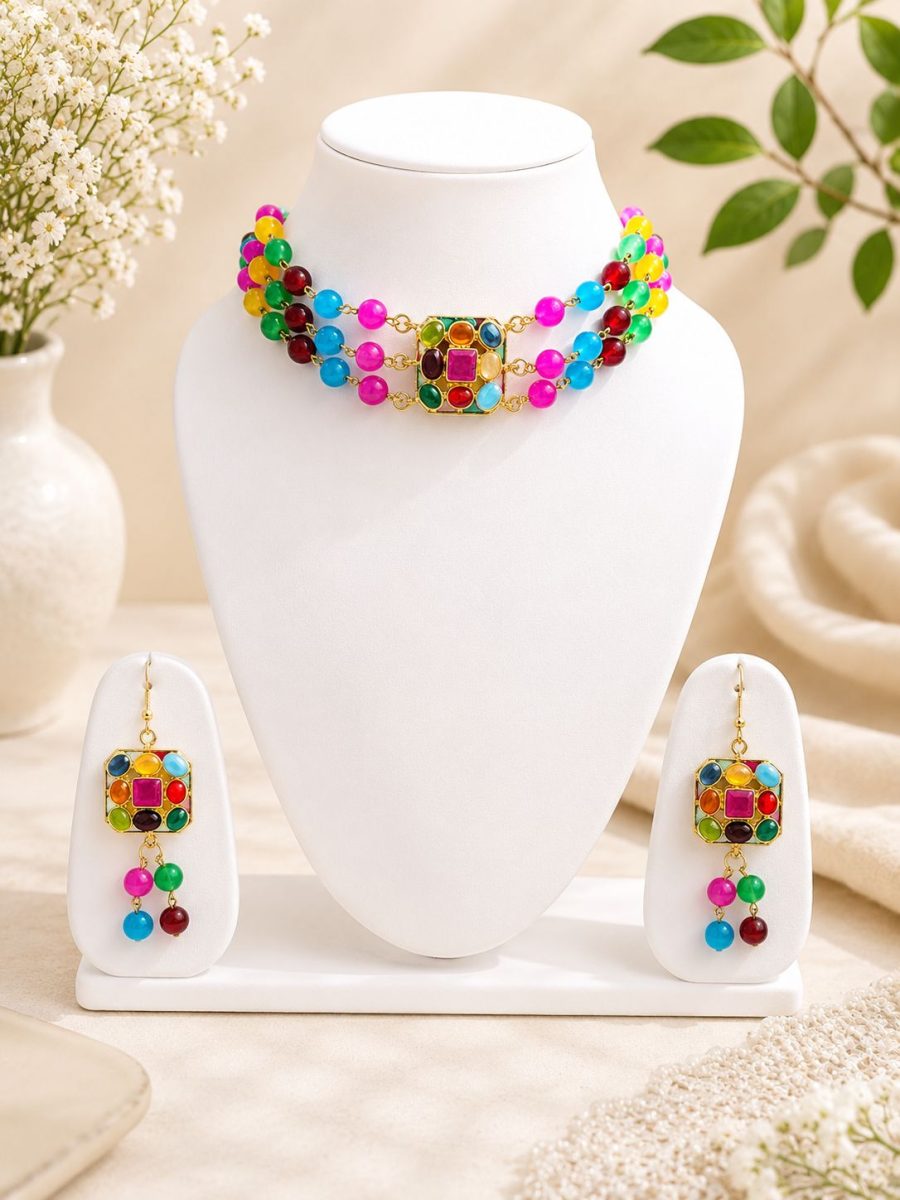 Multicolor beaded necklace set displayed on jewellery stand with matching earrings