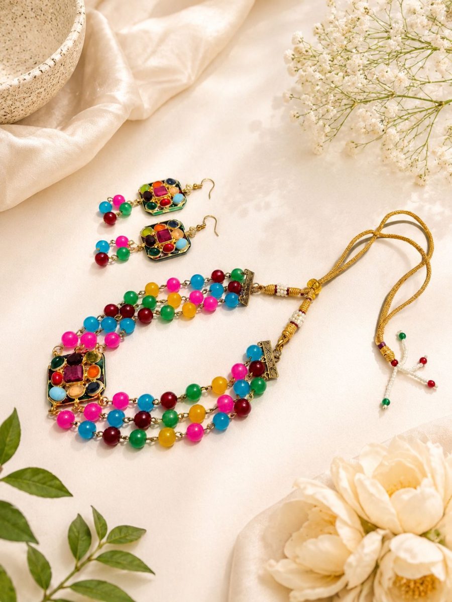 Flat lay view of multicolor bead necklace set with matching earrings and adjustable dori