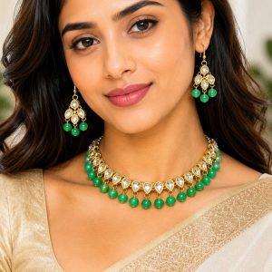 Woman wearing green Kundan choker necklace set with matching earrings
