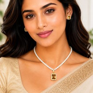 Woman wearing pearl pendant necklace set with champagne stone pendant and matching earrings