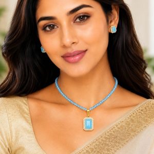 Woman wearing sky blue pendant necklace set with matching stud earrings