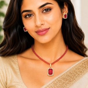 Woman wearing red crystal pendant necklace set with matching stud earrings