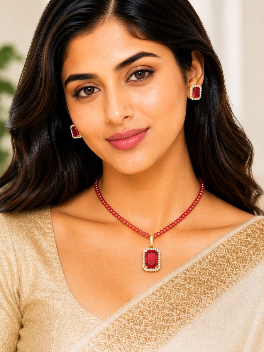 Woman wearing red crystal pendant necklace set with matching stud earrings
