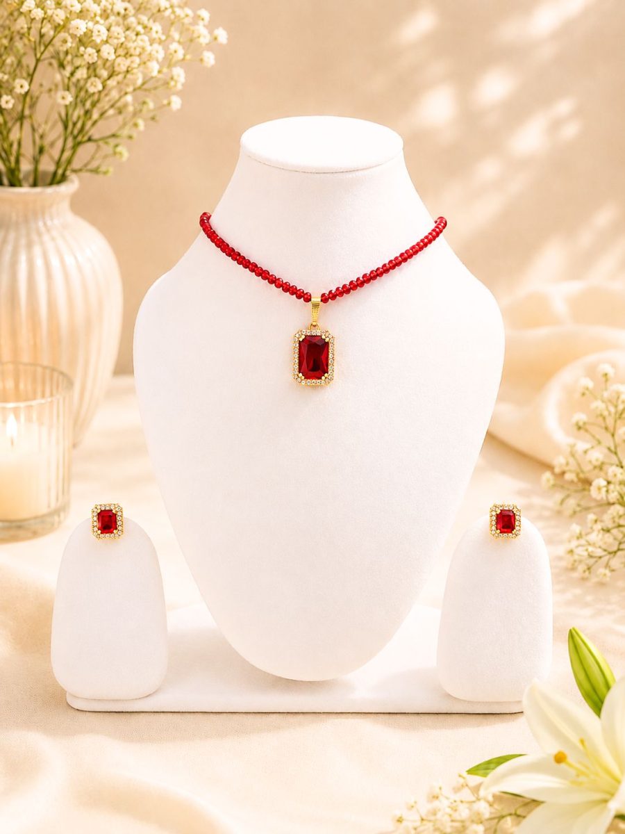 Red crystal pendant necklace set displayed on white jewellery stand