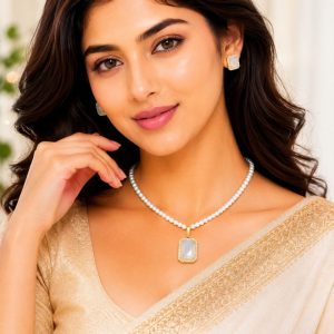 Woman wearing white crystal pearl pendant necklace set with matching stud earrings