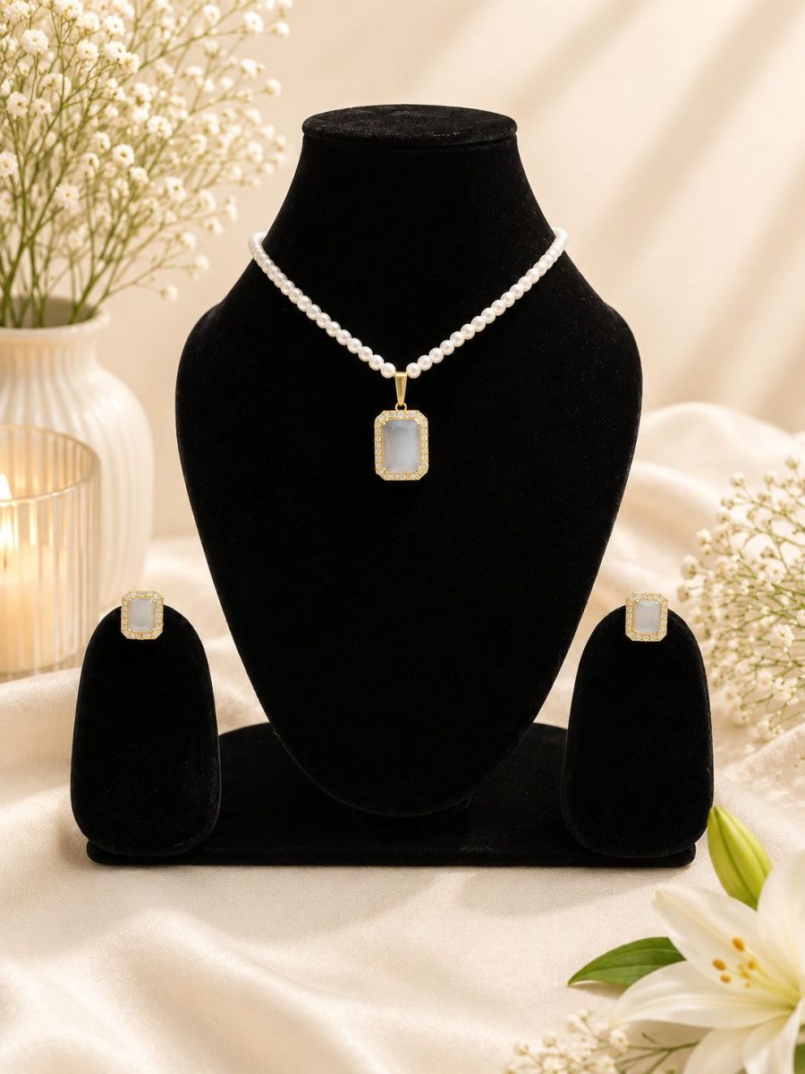 White crystal pendant necklace set displayed on black jewellery stand