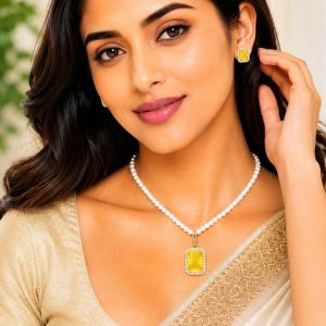 Woman wearing yellow crystal pearl pendant necklace set with matching stud earrings