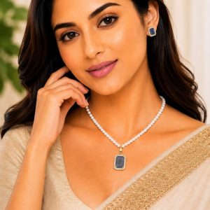 Woman wearing blue crystal pearl pendant necklace set with matching stud earrings