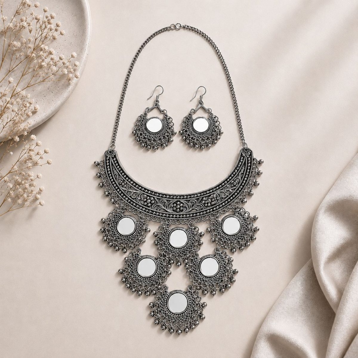 mirror necklace set with earrings on flat surface